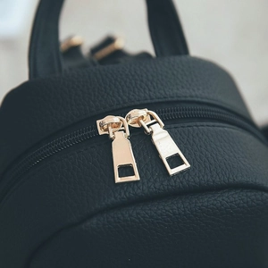 Detail of premium black PU leather texture with high-quality golden metal double zippers