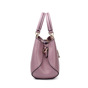 Purple faux leather tote bag with embroidered details and metallic feet in side view