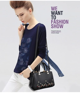 Fashionable black PU shoulder bag with intricate floral embroidery worn by a model