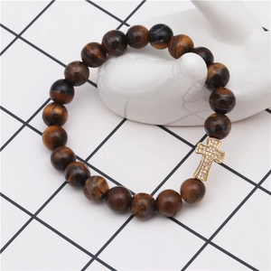 Macro shot of tiger eye beads bracelet with a gold-plated zircon cross on a white display