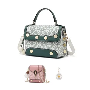 Detailed close-up of pink and beige crossbody bag with floral pattern and bear charm