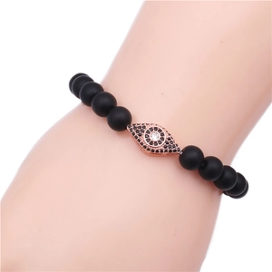 Detailed macro of Evil Eye charm with black matte beads and rose gold finish bracelet