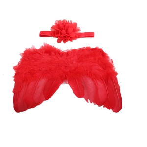 Détail macro d'ailes d'ange en plumes rouges et bandeau fleur pour séance photo bébé