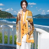 Detail of national style linen scarf with geometric horse pattern on a sunny beach