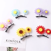 Detail of colorful sunflower hair clips with 3D texture and black metal duckbill base