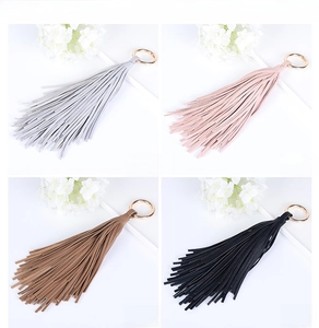 Détail de porte-clés à glands en cuir coloré avec anneaux en métal doré en quatre couleurs