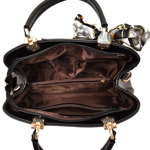Overhead view of a black leather handbag featuring multiple compartments and brown lining