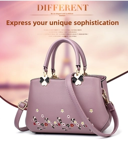 Close-up of lilac floral embroidered PU leather handbag with clover charm detail