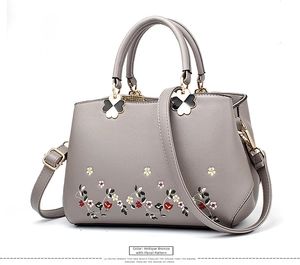 Close-up of floral embroidery on grey PU leather shoulder bag with clover charm