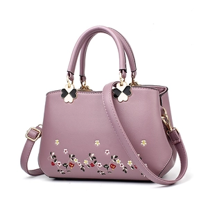 Purple faux leather tote bag with floral embroidery and clover hardware accents