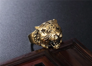Macro detail of a vintage tiger head ring in antique gold with intricate carvings