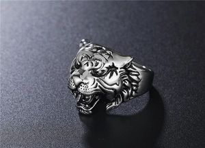 Detailed close-up showing the antique tiger head carving on a stainless steel ring