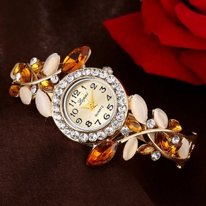 Lupai gold quartz watch with crystal bezel and floral petal bracelet on silk background