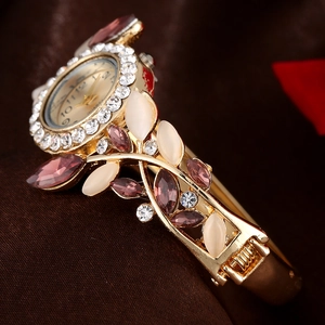 Elegant gold bangle watch for women featuring crystal floral accents and a rhinestone bezel