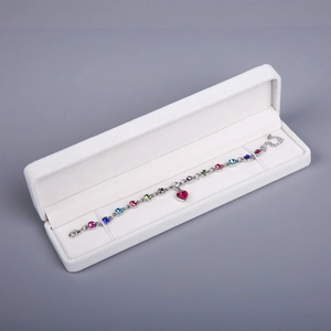 Detail of colorful crystal bracelet with red heart pendant in a white jewelry gift box