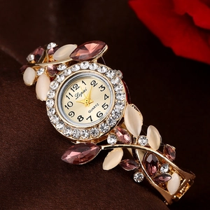 Detailed close-up of golden quartz watch with purple crystals and white opal accents