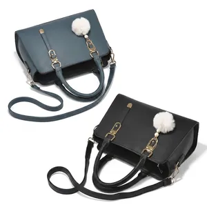 Detail view of pebbled leather tote bags in blue and black with gold hardware logo