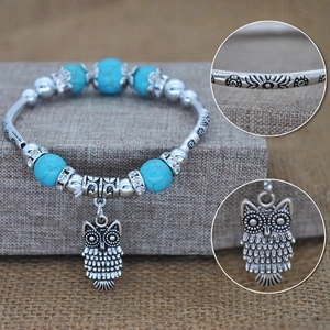 Detail of owl charm and turquoise beads on vintage silver bohemian stretch bracelet