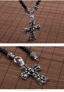Detail of silver skull cross pendant on black beaded necklace with a pirate theme