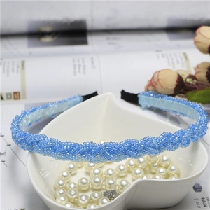 Detailed close-up of blue beaded braided headband in heart-shaped pearl bowl