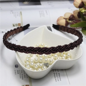 Macro shot of burgundy braided bead headband with detailed woven texture and pearl accents