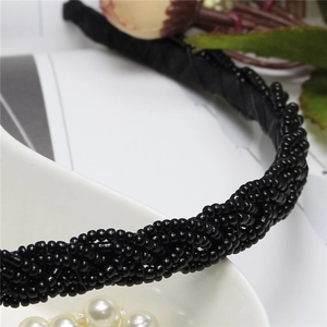 Close-up of black beaded twist braided headband with intricate pearl texture