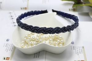 Detailed view of deep blue beaded braided headband inside a white heart ceramic dish