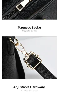 Detail of golden metal zipper and detachable lobster clasp on black lychee leather bag
