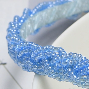 Macro shot of blue beaded twist hairband showing intricate craftsmanship and texture