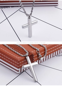 Vue détaillée du pendentif croix en argent poli avec une chaîne de style torsadé