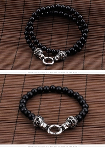 Detail of black beaded bracelet featuring vintage silver skull charms and round clasp