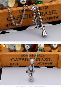 Detailed close-up of a vintage silver trumpet pendant with stainless steel rope chain