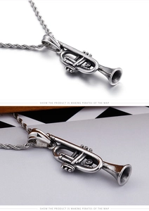 Macro shot of antique finish trumpet instrument pendant with twisted rope chain detail