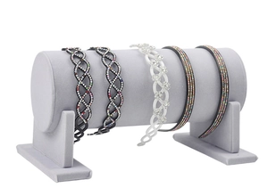 Detail of assorted rhinestone headbands on a gray cylindrical velvet display stand