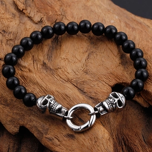 Punk style skull beaded bracelet featuring black beads and silver metal skull charms on wood
