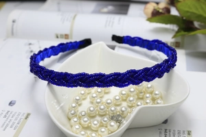 Detailed close-up of a braided navy blue beaded headband with woven pearl-like texture