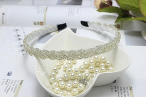 Detailed texture of silver beaded woven headband resting in a heart-shaped bowl