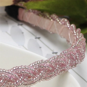 Close-up of pink and silver beaded braid texture on elegant fabric headband