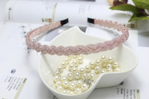 Detail of pink beaded woven headband resting on a decorative heart-shaped pearl bowl