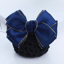 Detail of navy satin hair bow clip with gold trim and professional black mesh net