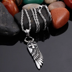 Silver stainless steel angel wing cross pendant necklace on black reflective surface