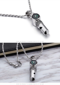 Close-up of silver stainless steel whistle pendant with integrated green compass detail
