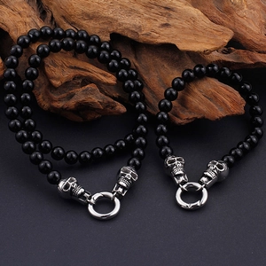 Punk style beaded bracelet with silver skull heads and black polished round beads