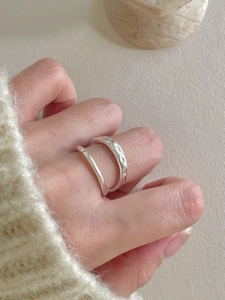 Close-up of S925 sterling silver layered ring with irregular hammered texture on model