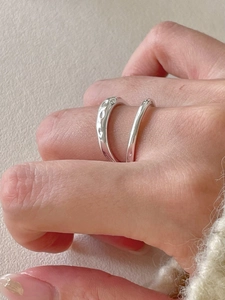 Detailed view of an irregular double-layer S925 sterling silver ring on a finger