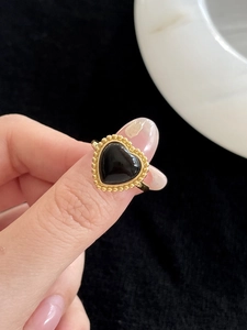 Détail d'une bague coeur en argent S925 avec onyx noir et bordure perlée dorée