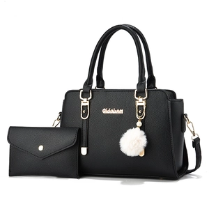 Black lychee leather handbag set with gold hardware and white faux fur pompom charm