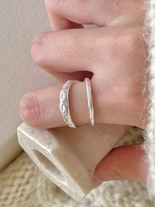 Macro shot of silver ring with irregular lava texture and unique hammered finish details