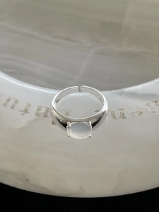 Macro detail of 925 silver adjustable ring featuring a bezel-set oval white crystal stone
