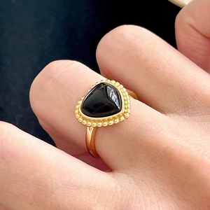 Bague élégante en argent S925 doré avec onyx noir en forme de cœur sur main de femme